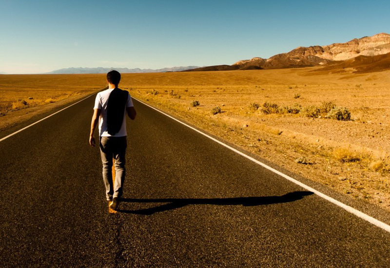 Guy walking down road traveling