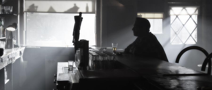 man drinking alone at bar