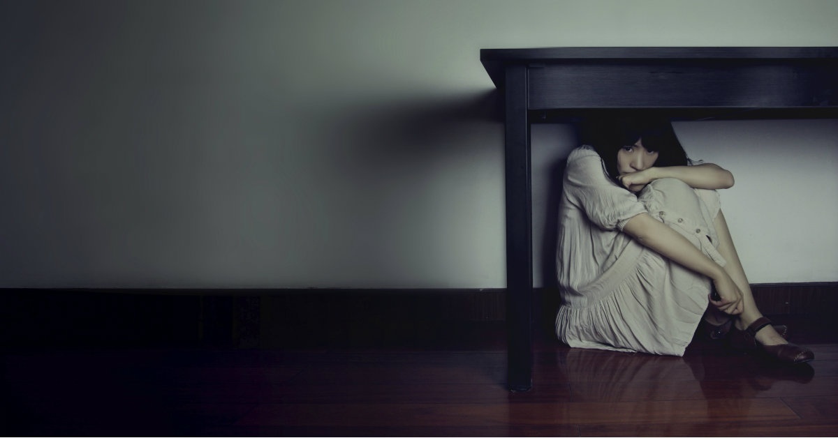 woman hiding under table